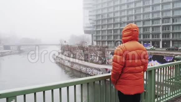 这家伙站在桥上看着奥地利雾中的城市视频的预览图