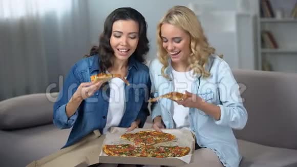 两名饥饿的女学生在室内享用美味的披萨视频的预览图