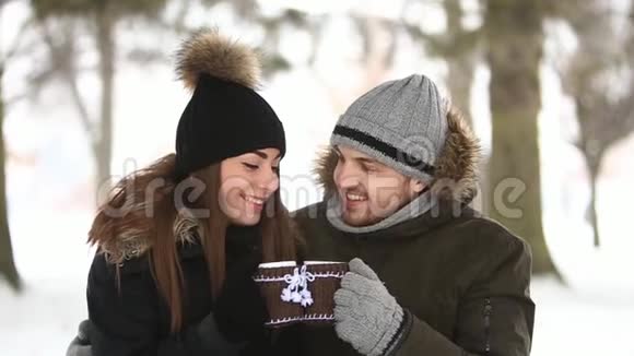 快乐的夫妻在冬天在一起他们在公园里煮热茶圣诞节的心情视频的预览图