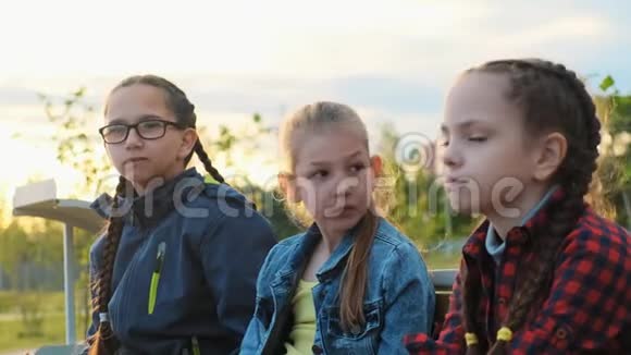 一群孩子朋友坐在长凳上吃饭视频的预览图