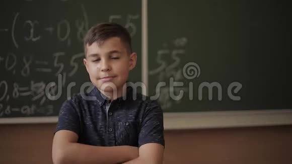 可爱的男孩站在黑板的教室背景里教育小学视频的预览图