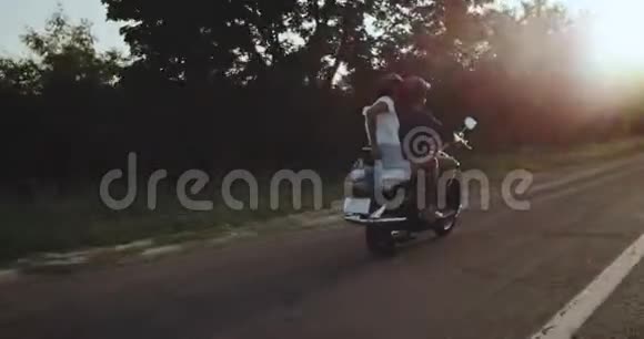 一对幸福快乐的恋人正骑着摩托车美丽明亮的日落景色视频的预览图