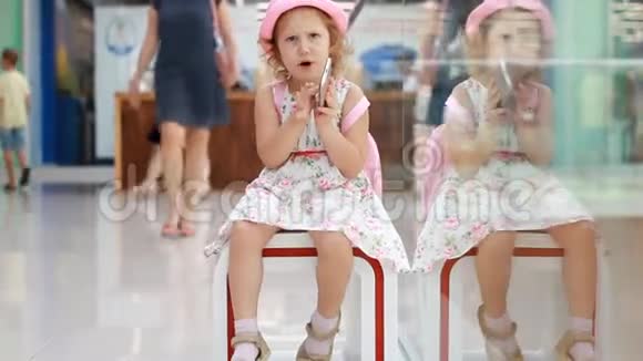 女孩在购物中心玩手机婴儿在智能手机上使用游戏应用程序视频的预览图