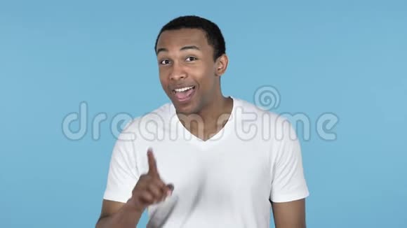 非洲男人的沉默嘴唇上的手指蓝色背景视频的预览图