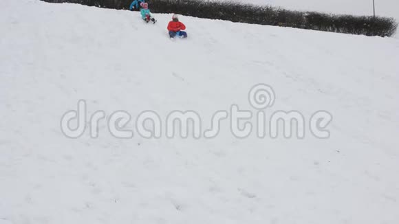 母亲带着两个女儿骑在一座雪山上在冬天玩得很开心视频的预览图