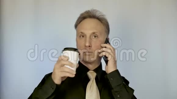 一个中等身材的男人喝咖啡打电话他领导商务谈判视频的预览图