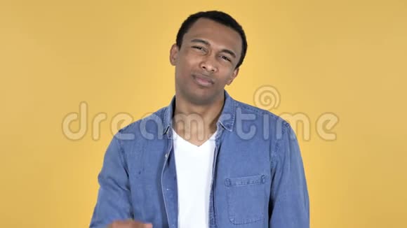 颈部疼痛的非洲青年男子黄色背景视频的预览图