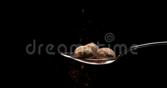 肉豆蔻肉豆蔻黑背景下粉上的肉豆蔻慢动作视频的预览图
