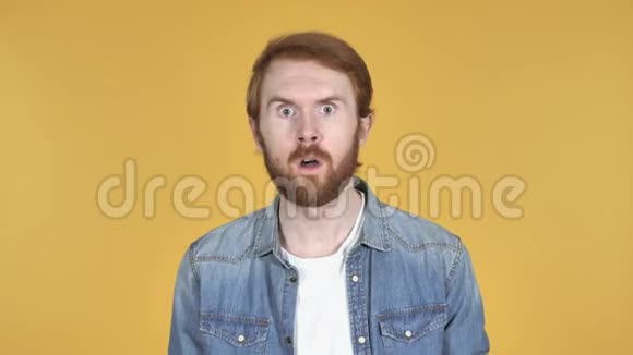红发男子困惑和恐惧的问题黄色的背景视频的预览图