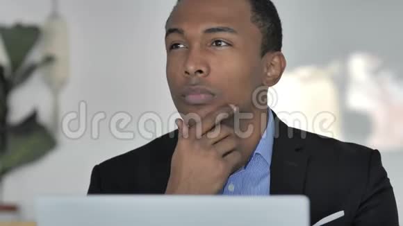 近距离思考非裔美国商人在笔记本电脑上工作正面观察视频的预览图