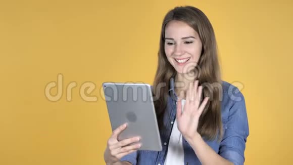 黄色背景下美女通过平板电脑进行视频聊天视频的预览图