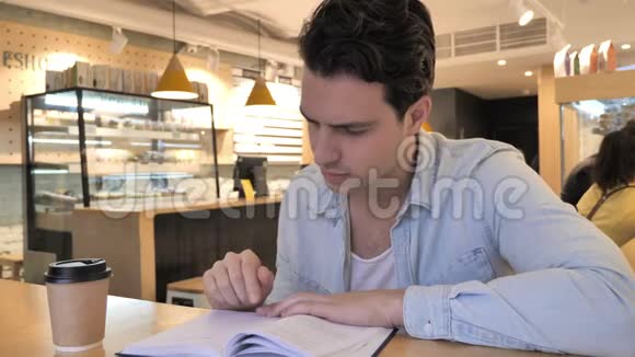 在咖啡厅放松青少年阅读书籍视频的预览图