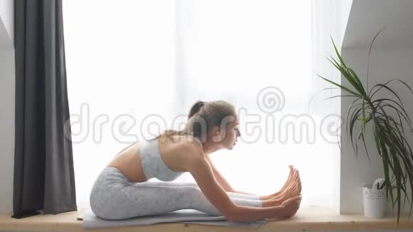 女人做体式练习坐前弯姿势健康的生活方式视频的预览图