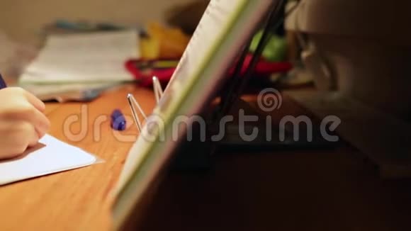 做作业的人在家做作业的特写男孩男孩手里拿着钢笔课本和笔记本男孩写信进来视频的预览图