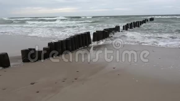 木桩在海滩和海浪上成堆的废墟视频的预览图