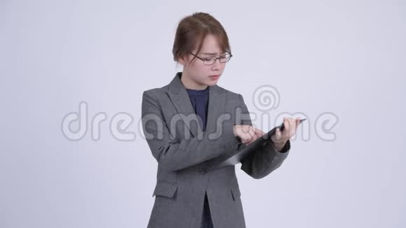 年轻严肃的亚洲女商人展示剪贴板竖起大拇指视频的预览图