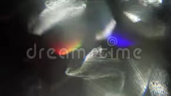 快速移动的抽象光泄漏彩虹全息箔反射在黑暗中视频的预览图