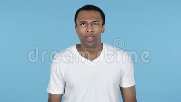 尖叫沮丧的非洲青年男子蓝色背景视频的预览图