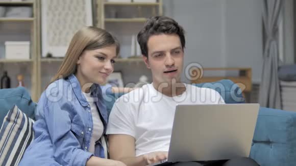 年轻夫妇在家里在笔记本电脑上在线视频聊天视频的预览图