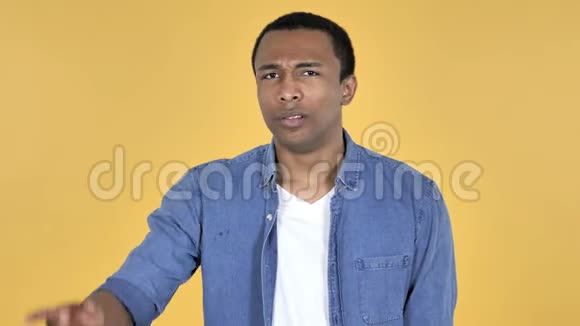 非洲青年男子挥舞手指拒绝黄色背景视频的预览图