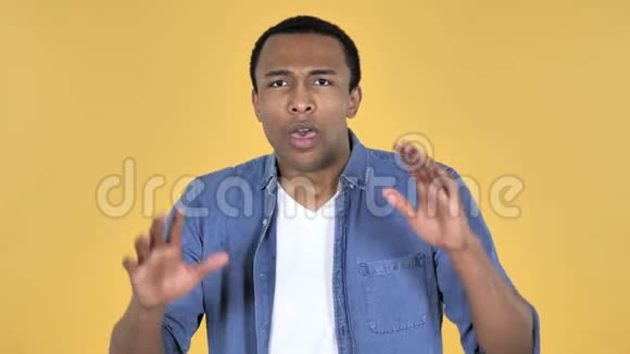 年轻的非洲男人困惑害怕问题黄色背景视频的预览图