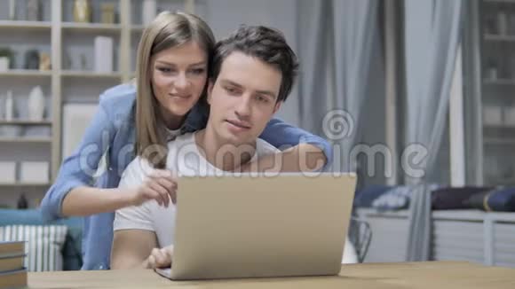 快乐的年轻夫妇用笔记本电脑在网上选购东西视频的预览图