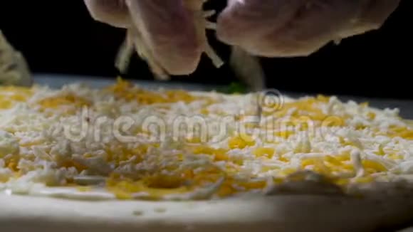 准备做饭我们的手戴着烹饪手套把奶酪放在披萨上四张奶酪框架厨师添加配料视频的预览图