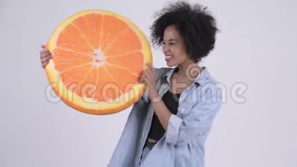 年轻快乐的非洲女人带着橙色的枕头视频的预览图