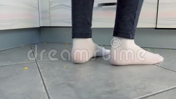 女人在厨房的肮脏地板上厨房地板上的剩菜和面包屑腿部特写视频的预览图