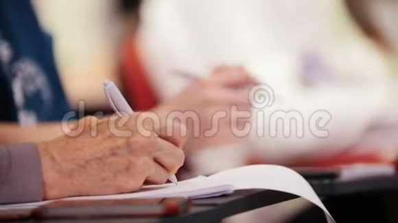 厅的商务会议一位老妇人坐在桌子旁在笔记本上做记号视频的预览图
