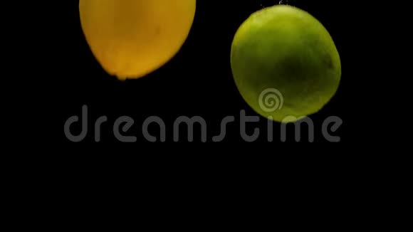 黄柠檬和青柠檬在黑色背景下落入透明水视频的预览图