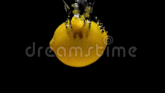 黄色柠檬在黑色背景下落入透明水视频的预览图