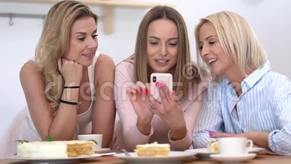 美丽的成年女性享受生日和使用智能手机视频的预览图