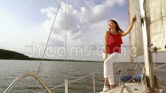 穿着红白衣服的女人站在帆船上视频的预览图