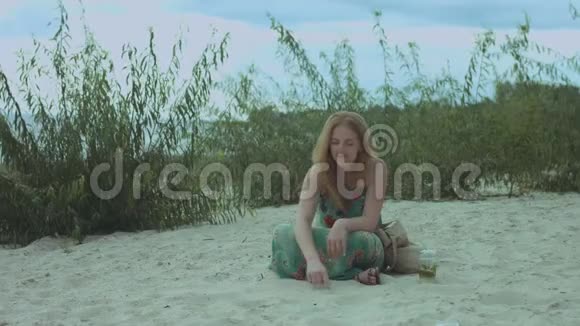 快乐的微笑的女人在海边的沙滩上画画视频的预览图