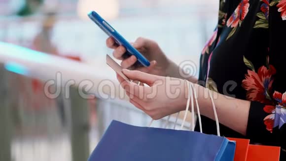 网上购物时使用手机和信用卡的女孩视频的预览图