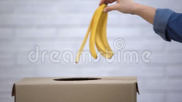 手把香蕉皮扔进垃圾桶回收垃圾分类特写视频的预览图