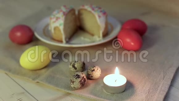 贺卡的背景特写点燃的蜡烛背景中五颜六色的复活节彩蛋和EAS视频的预览图