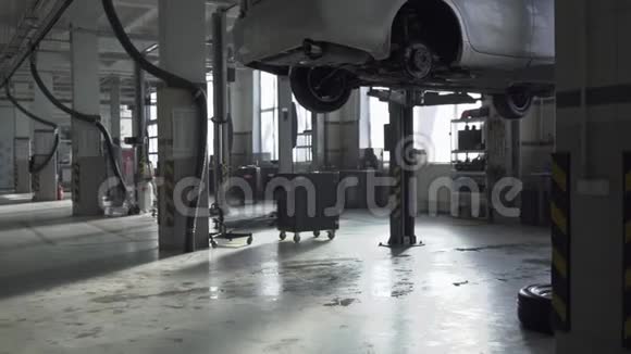 有需要修理的机器的服务站一辆车悬挂在地板上方第二辆在附近视频的预览图
