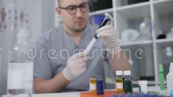 戴橡胶手套的医生将液体试剂拨入注射器实验室助理进行实验室研究视频的预览图