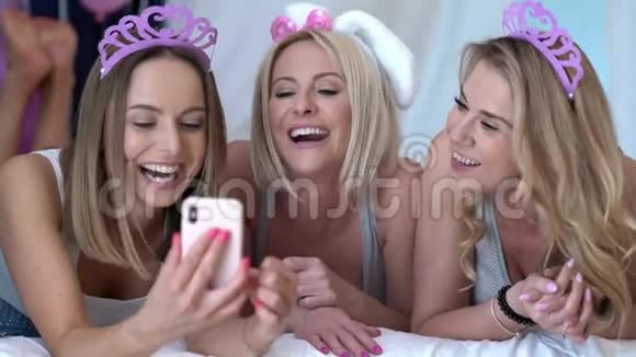 美丽的成年女性享受生日和使用智能手机视频的预览图