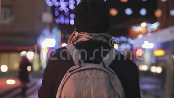 无法辨认的男人在夜城用智能手机和他的朋友交谈慢镜头视频的预览图