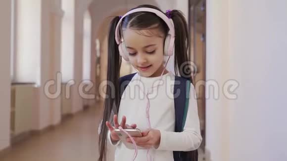 穿着粉色耳机听音乐的漂亮女孩视频的预览图