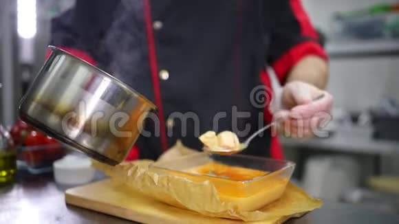 在厨房工作的厨师把肉汤倒在盛海鲜的玻璃碗里视频的预览图