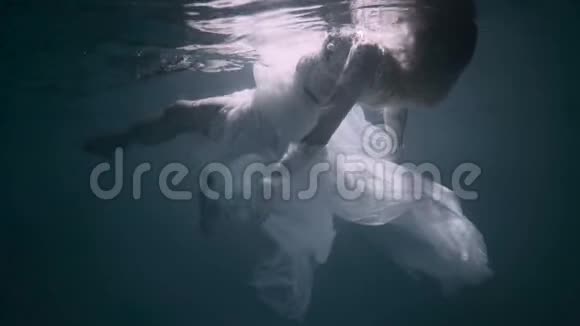 年轻的女人在水下她穿着一件白色的裙子视频的预览图
