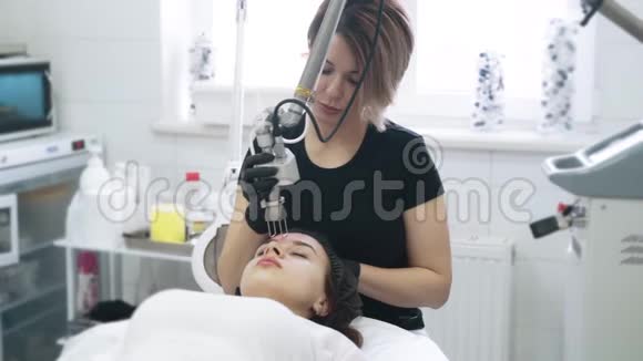 慢动作美容师为特殊设备的女性做激光面部剥皮视频的预览图