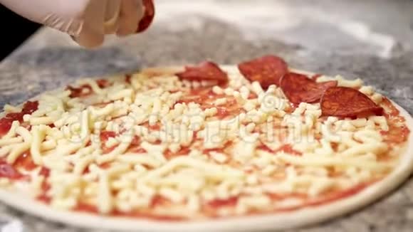 把意大利辣香肠切片放在芝士披萨上视频的预览图