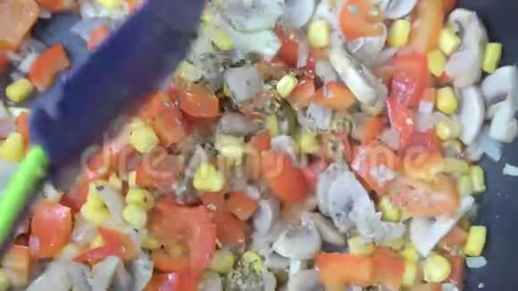 蔬菜的特写被炒在平底锅里用铲子搅拌视频的预览图