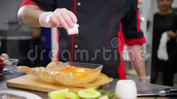 在厨房工作的厨师在肉汤里加入酱汁视频的预览图