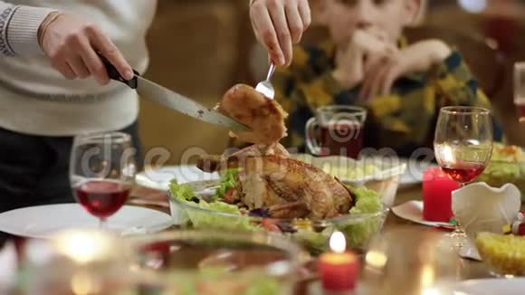亲爱的丈夫在圣诞桌上切一条火鸡腿然后把它放在他妻子盘子里视频的预览图